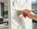 Gently dusting a textured acoustic art painting with a soft bristle brush.